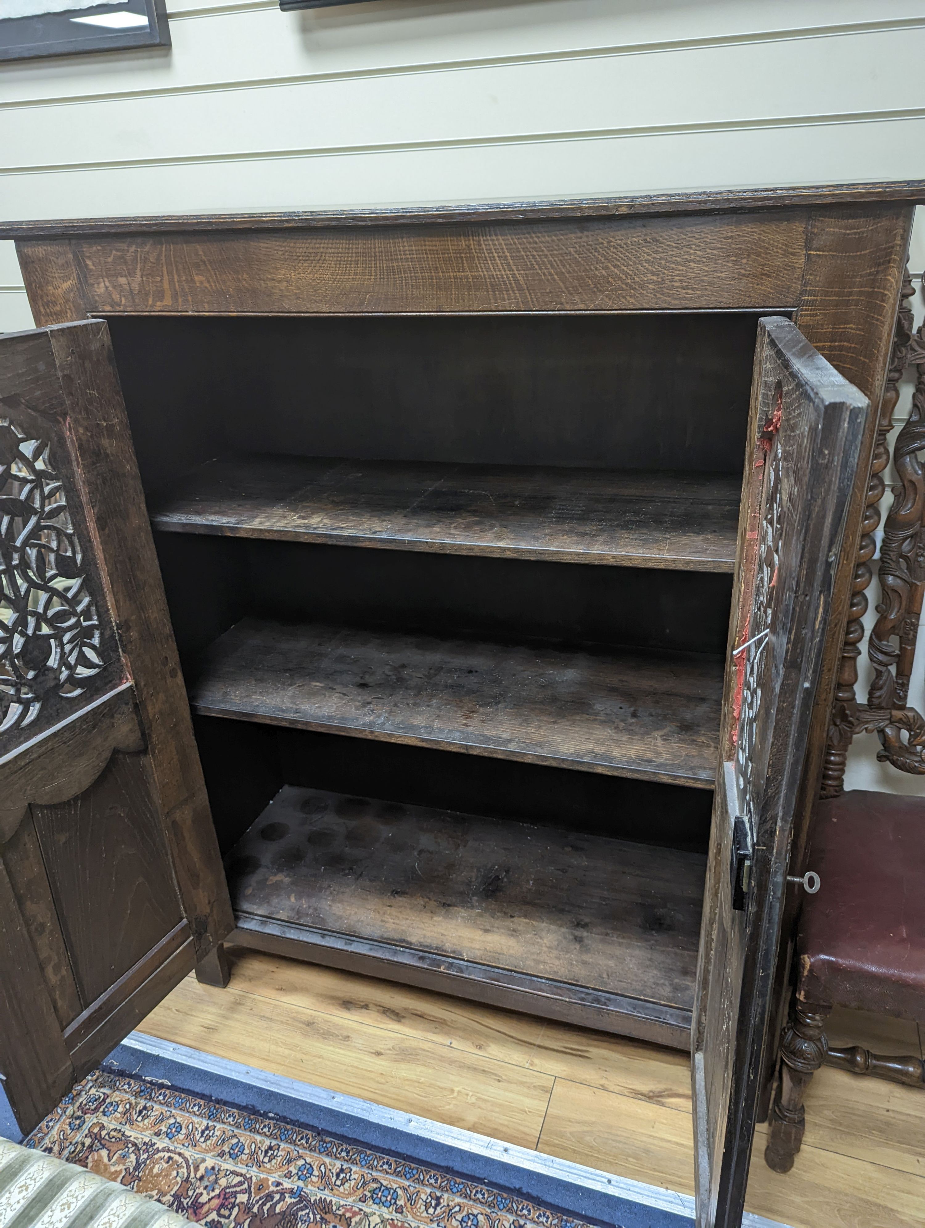 An 18th century and later French carved oak side cabinet. W-112cm, D-46cm, H-136cm.